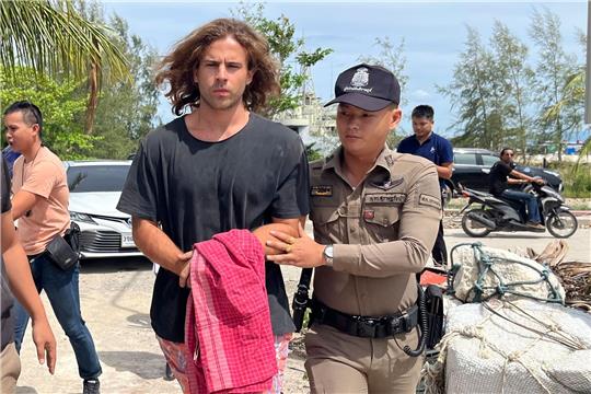 Ein thailändischer Polizist (r.) eskortiert einen Spanier, der unter Verdacht steht, einen  Chirurgen ermordet  zu haben.