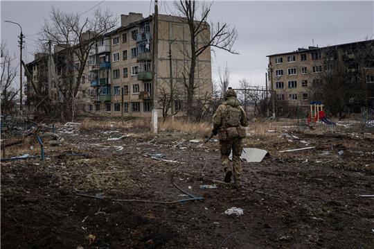 Ein ukrainischer Marinesoldat geht in Wuhledar an zerstörten Wohnblocks vorbei.