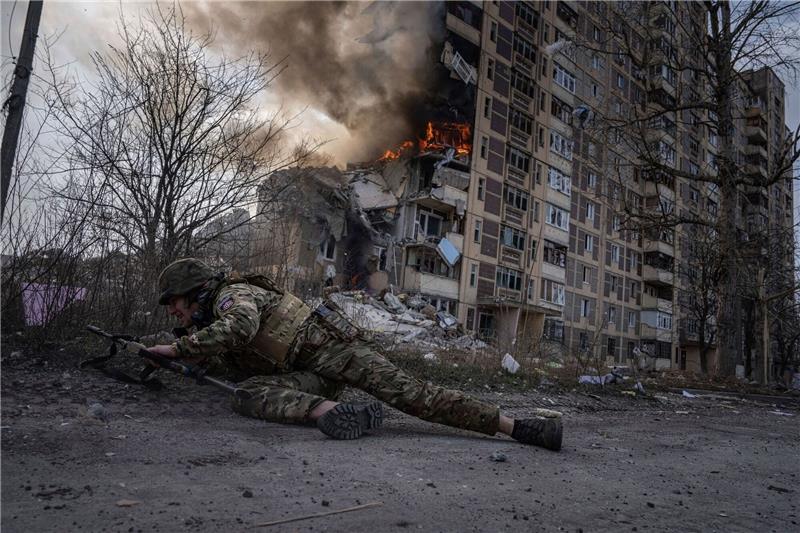 Ukraine-Krieg: So ist die Lage Ein ukrainischer Polizist geht in Awdijiwka vor einem brennenden Gebäude in Deckung.