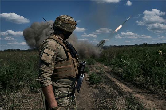 Ein ukrainischer Soldat beobachtet, wie ein Grad-Mehrfachraketenwerfersystem in der Nähe von Bachmut Raketen abfeuert.
