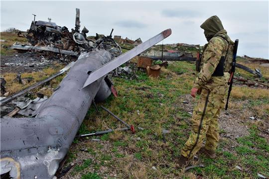 Ein ukrainischer Soldat betrachtet auf der Schlangeninsel im Schwarzen Meer ein zerstörtes russisches Militärflugzeug.