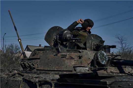 Ein ukrainischer Soldat gestikuliert auf einem gepanzerten Mannschaftstransportwagen an der Frontlinie in Bachmut.
