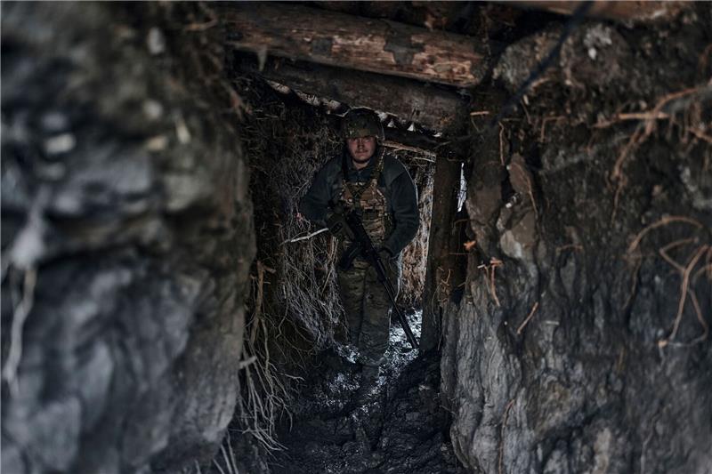 Ein ukrainischer Soldat steht in einem Graben an der Frontlinie einer Kleinstadt.