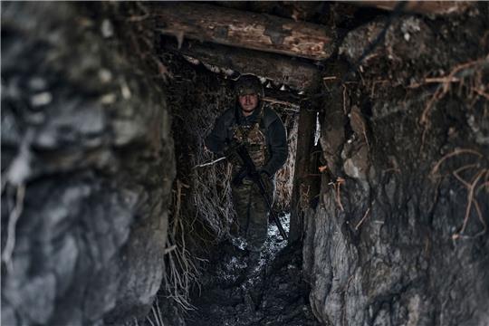 Ein ukrainischer Soldat steht in einem Graben an der Frontlinie einer Kleinstadt.