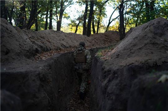 Ein ukrainischer Soldat überprüft die von russischen Soldaten ausgehobenen Schützengräben.
