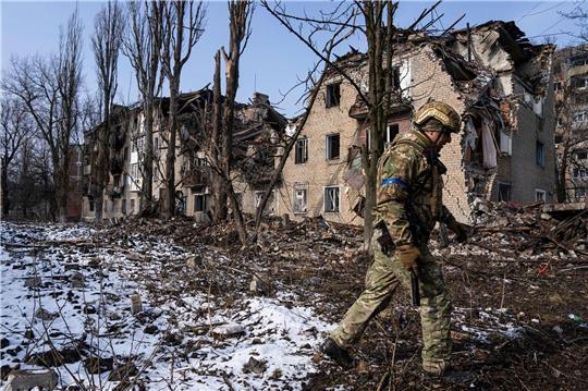 Ein ukrainischer Soldat vor einem zerstörten Wohnhaus in der ostukrainischen Stadt Awdijiwka.