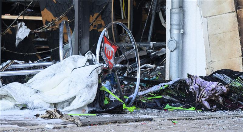 Ein umgestürzter Ständer mit einem Euro-Symbol liegt nach einem Brand vor einem Tedi-Markt. Das Feuer war am Vorabend aus ungeklärter Ursache in dem Einkaufsmarkt ausgebrochen.