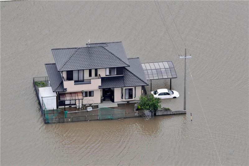Mindestens ein Toter nach heftigen Regenfällen in Japan Ein vom Hochwasser umschlossenes Haus in Toyokawa.