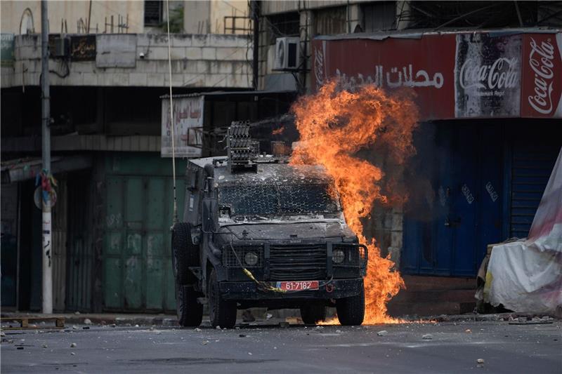 Zwei bewaffnete Palästinenser bei Razzia in Nablus getötet Ein von einem palästinensischen Demonstranten geworfener Molotowcocktail explodiert auf einem israelischen gepanzerten Fahrzeug in Nablus.
