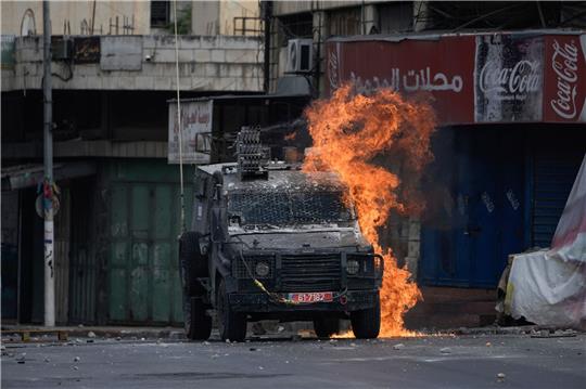 Ein von einem palästinensischen Demonstranten geworfener Molotowcocktail explodiert auf einem israelischen gepanzerten Fahrzeug in Nablus.