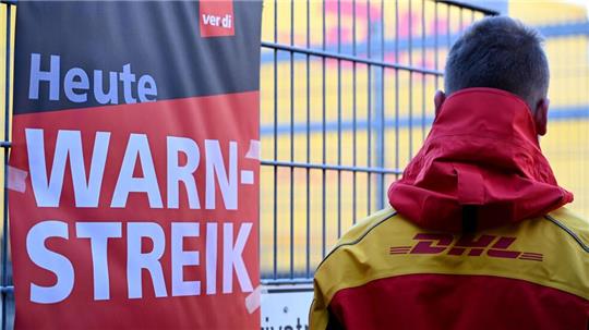 Ein warnstreikender DHL-Mitarbeiter an einem Standort der Post, die zu DHL gehört.