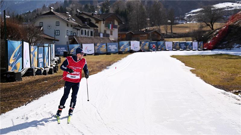 Ein weißer Streifen in viel grün: Frühlingshafte Temperaturen sorgen für schwere Bedingungen im Langlaufstadion. 