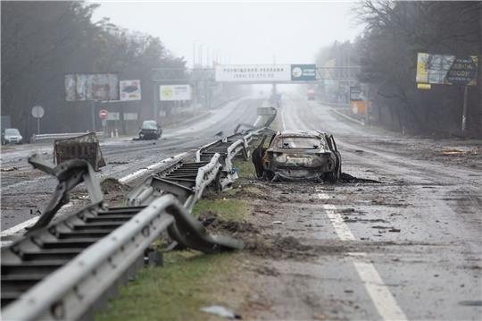 Ein zerstörtes Auto auf einer Landstraße bei Butscha.