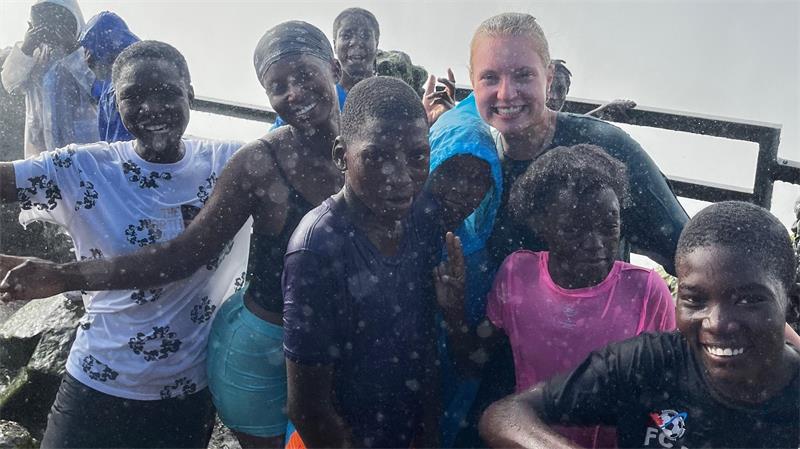 Gruppe von Kindern und Jugendlichen steht dicht beieinander und blickt in die Kamera