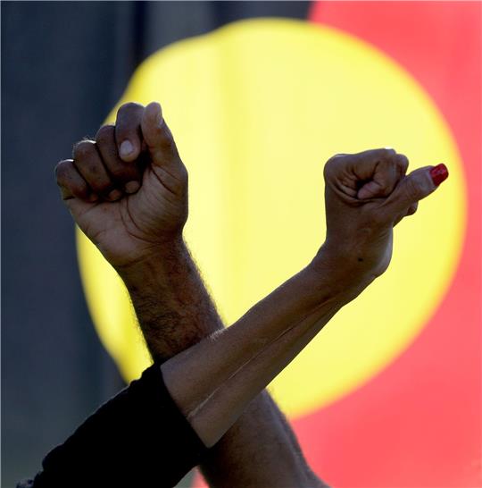 Ein Mann und eine Frau verschränken die Arme vor einer Aborigines-Flagge während einer Kundgebung der Bewegung «Black Lives Matter» in Sydney (Symbolbild). Der «Sydney Morning Herald» hat sich für seine Berichterstattung zum Myall-Creek-Massaker entschuldigt.