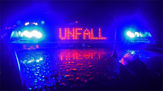 Ein Blaulicht auf einem Polizeifahrzeug mit der roten Aufschrift „Unfall“.