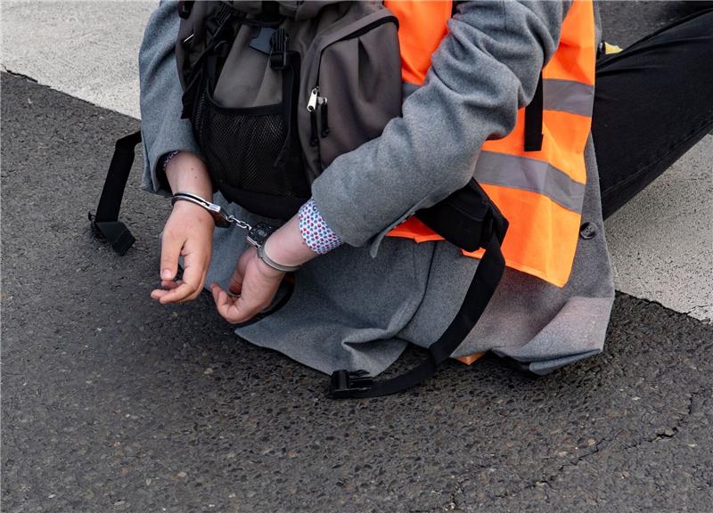 Polizeichefin: Staatliche Gewalt gegen Blockierer geht Eine Aktivistin der Gruppe Letzte Generation sitzt mit Handschellen auf einer Kreuzung in Berlin (Symbolbild).