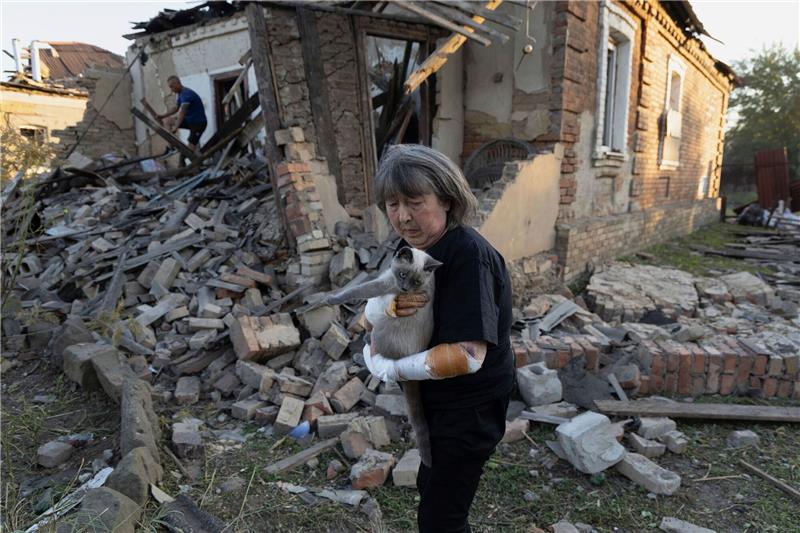 Krieg gegen die Ukraine: So ist die Lage Eine Anwohnerin steht vor ihrem Haus, das durch einen Raketenangriff in Kostjantyniwka in der Region Donezk beschädigt wurde.