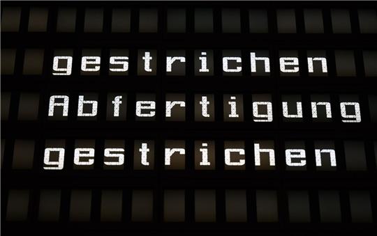 Eine Anzeigetafel im Flughafen informiert über ausgefallene Flugverbindungen.