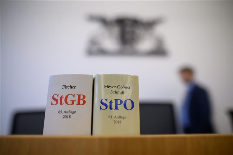 Eine Ausgabe des Strafgesetzbuchs und der Strafprozessordnung stehen in einem Gerichtssaal.