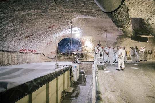 Eine Besuchergruppe steht im Atommülllager Asse neben einem Sammelbecken für radioaktiv belastete Lauge. In der Asse lagern seit mehr als 50 Jahren Fässer mit schwach- und mittelradioaktiven Abfällen. Foto: Ole Spata / dpa