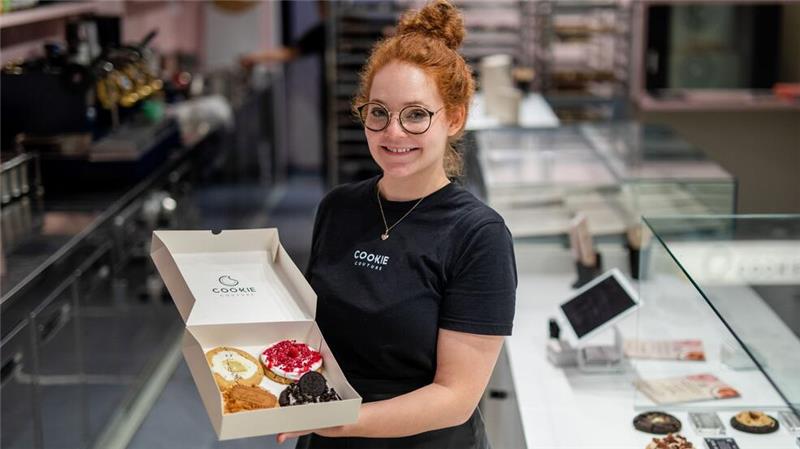 Eine Box mit frisch gebackenen und belegten Cookies präsentiert Mitgründerin Julia Boes.
