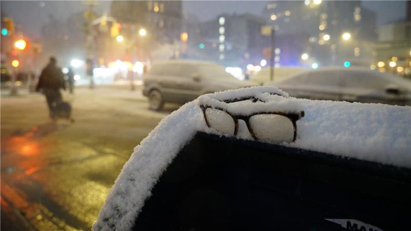 Eine Brille liegt während eines Schneesturms in New York im Schnee auf einem Briefkasten.