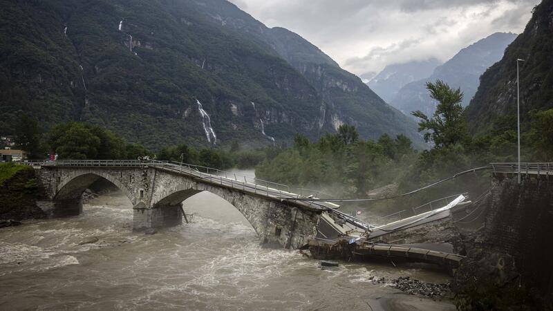 Eine Brücke im Maggiatal wird durch einen reißenden Fluss zerstört.