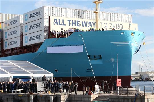Eine Champagnerflasche zerschellt am Rumpf des weltweit ersten mit grünem Methanol betriebenen Containerschiff.
