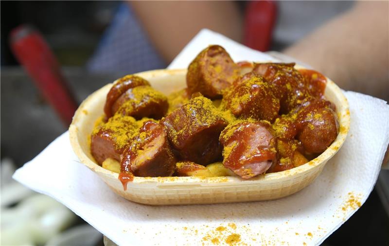 Eine Currywurst wird in einer essbaren Schale verkauft.