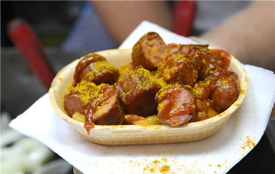 Eine Currywurst wird in einer essbaren Schale verkauft.