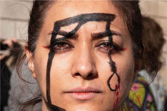 Eine Demonstrantin in Barcelona hat einen Galgen auf ihr Gesicht gemalt, um an die Hinrichtung von Mohsen S. zu erinnern.