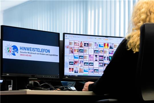 Eine Ermittlerin sitzt vor Monitoren mit unkenntlich gemachten Fotos, von denen einige sexuellen Missbrauch zeigen. Foto/dpa