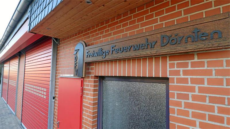 Feuerwehrgerätehaus mit drei Garagentoren, auf einem Holzschild steht Freiwillige Feuerwehr Dörnten