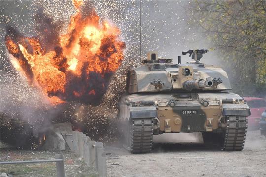 Eine Explosion ereignet sich in der Nähe eines Kampfpanzers vom Typ Challenger 2.