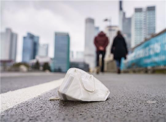 Eine FFP2-Maske liegt auf dem Gehweg der Frankfurter Untermainbrücke.