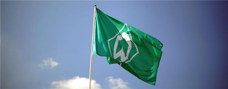 Eine Fahne mit dem Vereinslogo des Fußball-Bundesligisten SV Werder Bremen weht.
