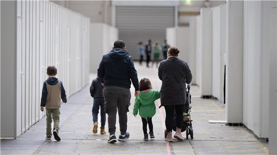 Eine Familie auf dem Weg zu einer Messehalle, die zur Asylunterkunft umfunktioniert wurde.