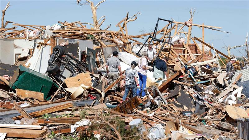 Eine Familie blickt nach einem Tornado durch die Trümmer ihres Hauses im Stadtteil Grayridge in Oklahoma.