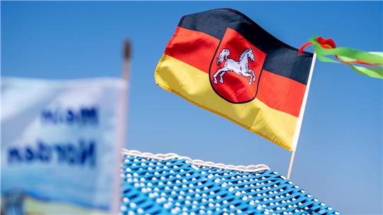 Eine Flagge dem Wappen von Niedersachsen weht auf einem Strandkorb auf Borkum. (Symbolbild)