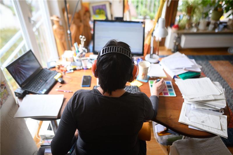 Firmen sehen keinen Produktivitätsverlust im Homeoffice Eine Frau arbeitet mit Hörschutz im Homeoffice.