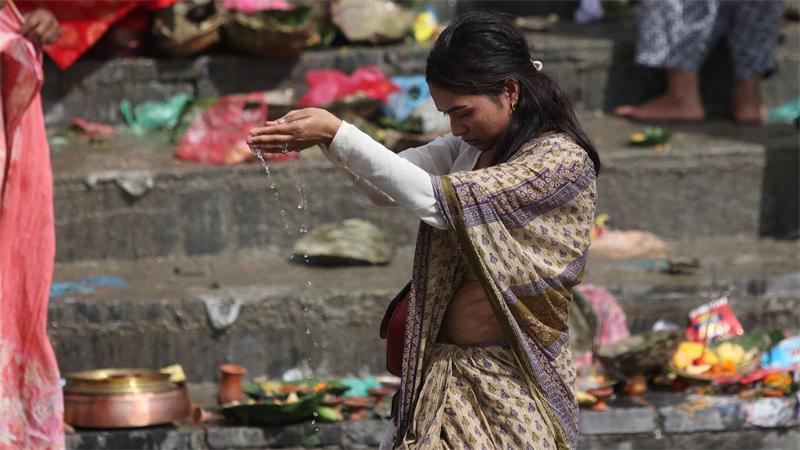 Eine Frau begeht in Nepal Kushé Aunshi, den Vatertag, an dem lebende und verstorbene Väter geehrt werden. 