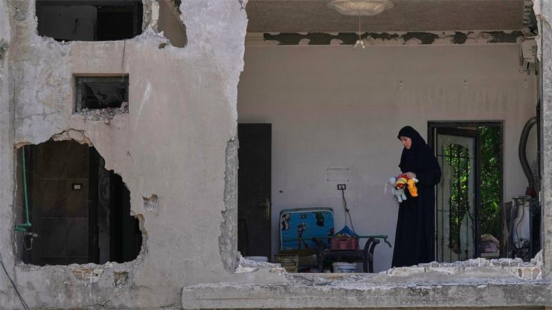 Eine Frau begutachtet ihr beschädigtes Haus an der Stelle einen Tag nach einem israelischen Luftangriff im Dorf Arab Salim im Südlibanon.