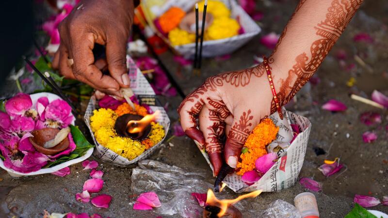 Eine Frau betet beim Teej-Fest und führt ein hinduistisches Opferritual in Prayagraj durch. In dem Ort fließen die Flüsse Ganges und Yamuna zusammen, weshalb er für Hindus eine besondere Bedeutung hat.