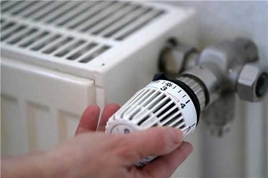 Eine Frau dreht an einem Heizungsthermostat. Die von der Bundesregierung geplante Entlastung vieler Mieter bei der Heizkosten-Klimaabgabe kommt voran. Foto: picture alliance/dpa | Marcus Brandt