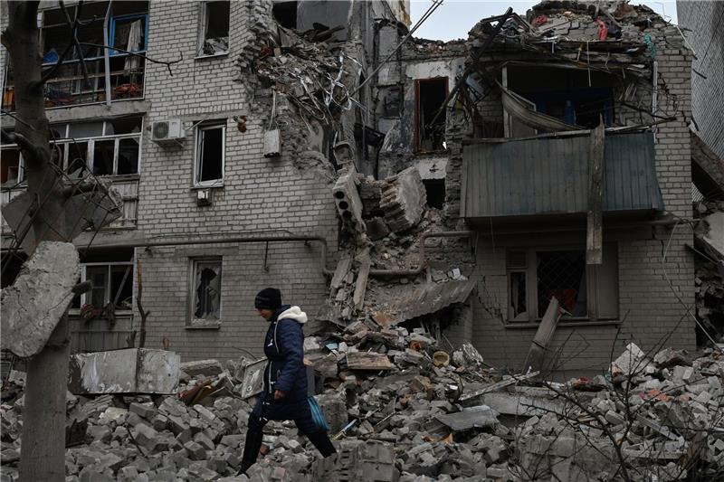 Krieg gegen die Ukraine: So ist die Lage Eine Frau geht an den Trümmern eines zerstörten Hauses nach einem Luftangriff vorbei.