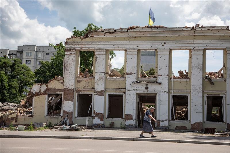 Prominente fordern Waffenstillstand in der Ukraine Eine Frau gehtan den Ruinen der Stadtverwaltung von Ochtyrka vorbei.
