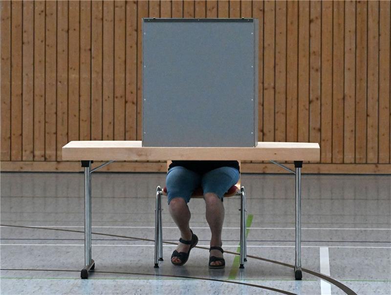 Viele Unionsanhänger für Gespräche CDU/Linke im Osten Eine Frau gibt in einem Wahllokal ihre Stimme ab.