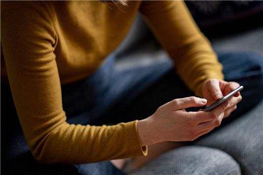 Eine Frau hält ein Smartphone in den Händen. Symbolfoto: DPA