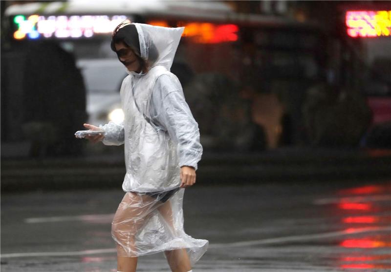 Taiwan: Eine Tote und mehr als 300 Verletzte durch Taifun Eine Frau läuft bei Regen und Wind durch Taipeh.